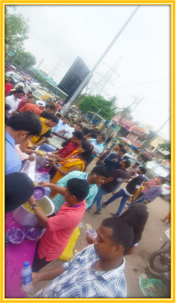 Volunteers distribute bottled water to pilgrims at the Bahuda Yatra.