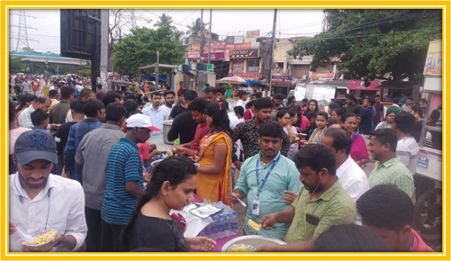 Crowds are served food and water along the festival route.